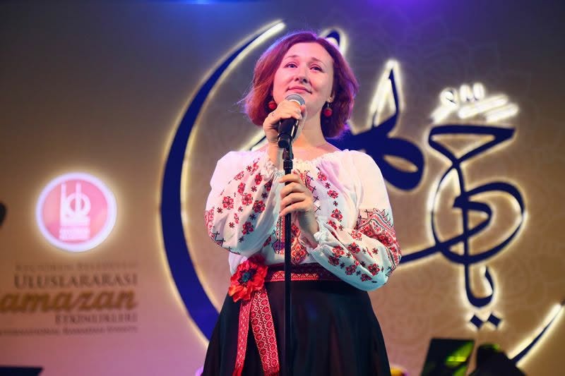 Olena Simsek performing on stage under event lighting